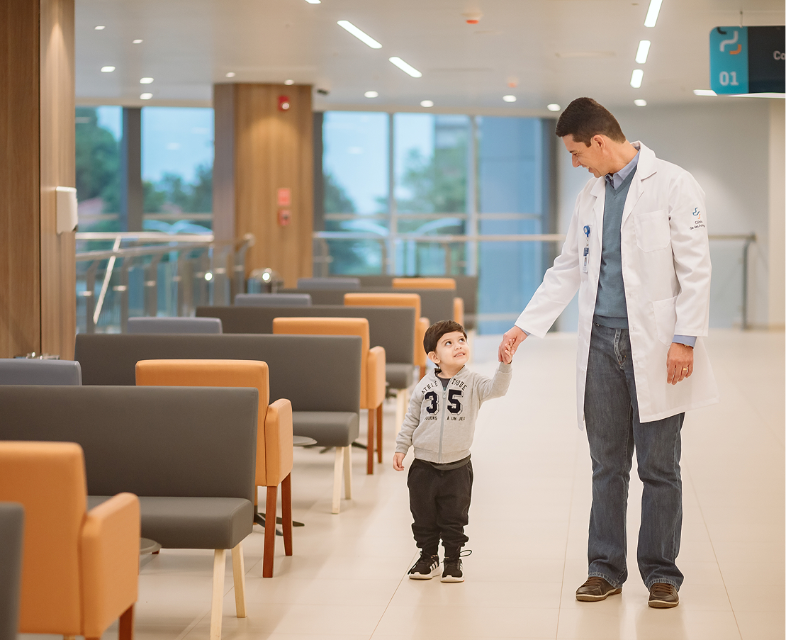 Médico acompañando a un niño en Clínica de Las Américas