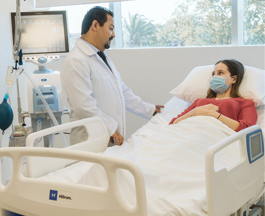Médico acompañando a una paciente en la Unidad de Terapia Intensiva para Adultos